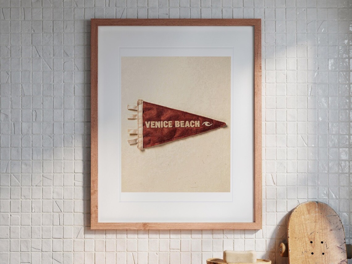Venice Beach print in a Red Oak frame with a white mat, hanging above the vanity in a bright bathroom.