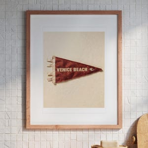 Venice Beach print in a Red Oak frame with a white mat, hanging above the vanity in a bright bathroom.