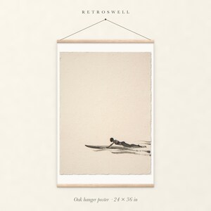 Paddling Surfer Ink Style oak hanger poster, 24 by 36 inches, with natural wood rails and a hanging cord.