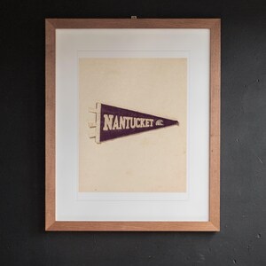 Nantucket print in a Red Oak frame with a white mat, hanging above the desk in a home office.