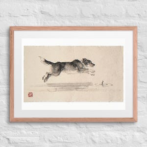Dog Chasing a Stick Xieyi Ink print in a Red Oak 24 by 18 inch frame with a white mat on a white brick wall.