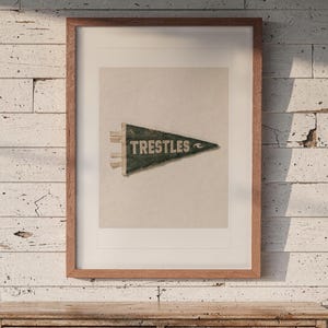 Trestles print in a Red Oak frame with a white mat, hanging above the dresser in a surf shack bedroom.