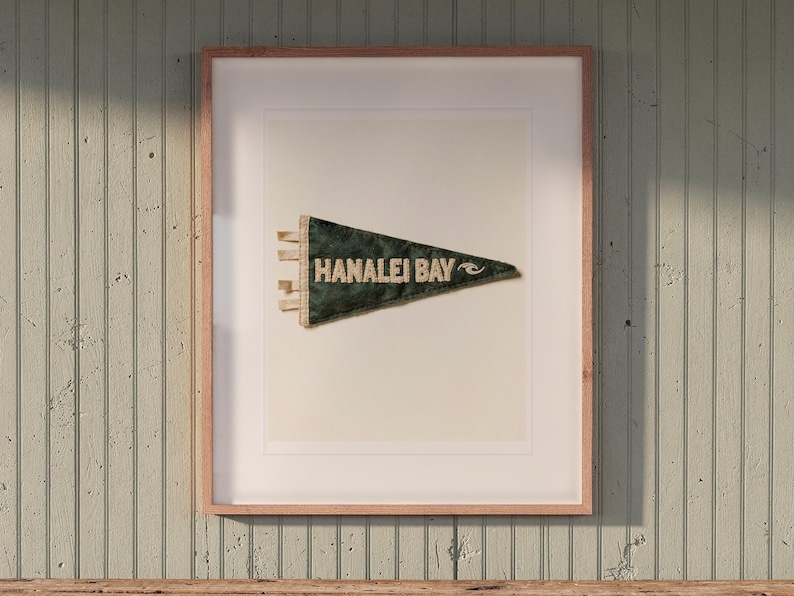 Hanalei Bay Surf Pennant print in a Red Oak frame with a white mat, hanging above the bench in a beach cottage entryway.