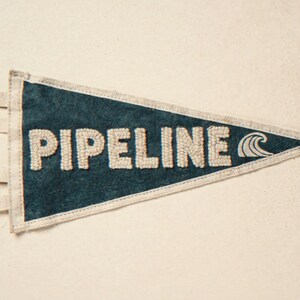 Pipeline Vintage Surf Pennant Print framed in a coastal dining room setting
