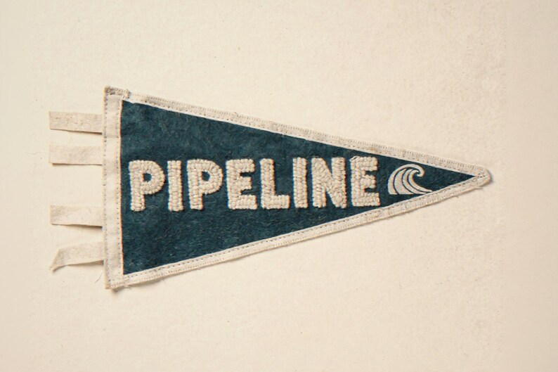 Pipeline Vintage Surf Pennant Print framed in a coastal dining room setting