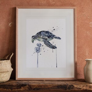Sea Turtle Watercolor print in a Red Oak frame with a white mat, leaning on the bench against the wall in a boho living room.