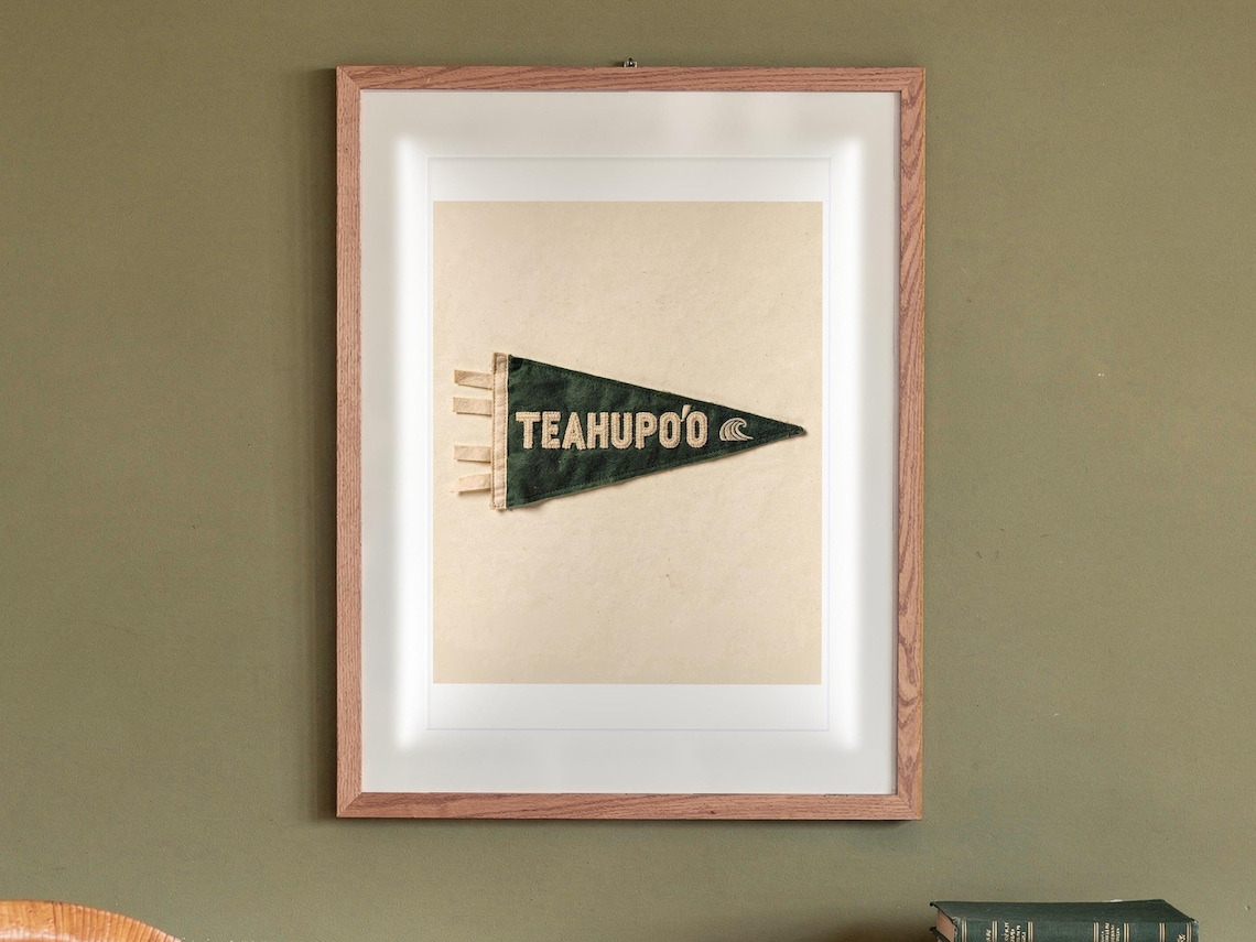 Teahupo'o Surf Pennant print in a Red Oak frame with a white mat, hanging above the sideboard in a mid-century living room.
