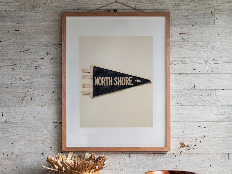 North Shore print in a Red Oak frame with a white mat, hanging above the dresser in a surf shack bedroom.