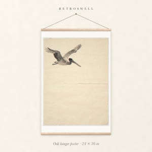 Flying Pelican Ink Style oak hanger poster, 24 by 36 inches, with natural wood rails and a hanging cord.