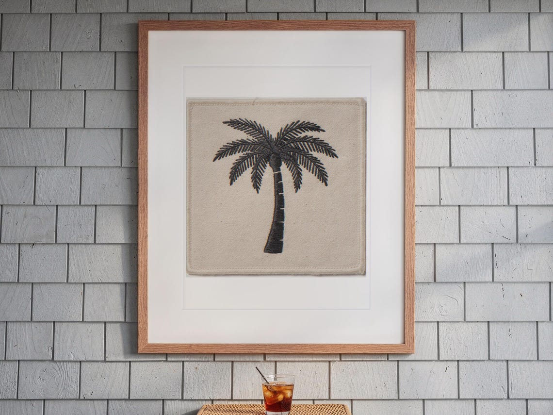 Palm Tree Patch print in a Red Oak frame with a white mat, hanging above the table in a screened beach porch.