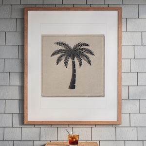 Palm Tree Patch print in a Red Oak frame with a white mat, hanging above the table in a screened beach porch.