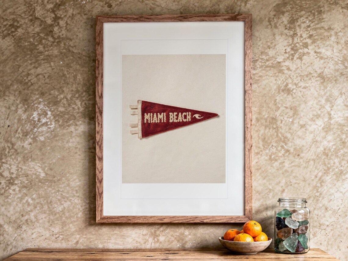 Miami Beach print in a Red Oak frame with a white mat, hanging above the vanity in a bright bathroom.