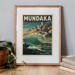 Mundaka Spain Surf Travel Poster print in a Red Oak frame with a white mat, standing on the floor, leaning back slightly against the wall in a living room floor lean.