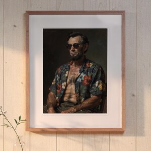 May include: A framed portrait print featuring a man with a beard and dark hair wearing dark sunglasses and an unbuttoned short-sleeved shirt with a dark blue background and a colorful tropical floral pattern of red and white hibiscus flowers.