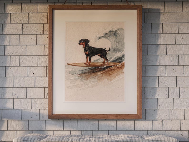 Doberman Surfing printable art, shown printed in a Red Oak frame with a white mat, hanging above the bench in a screened beach porch.