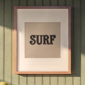 Surf Patch print in a Red Oak frame with a white mat, hanging above the bench in a mudroom.