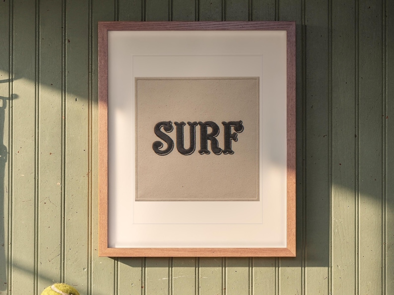 Surf Patch print in a Red Oak frame with a white mat, hanging above the bench in a mudroom.