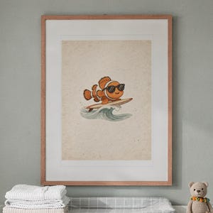 Surfing Clownfish print in a Red Oak frame with a white mat, hanging above the dresser in a nursery.