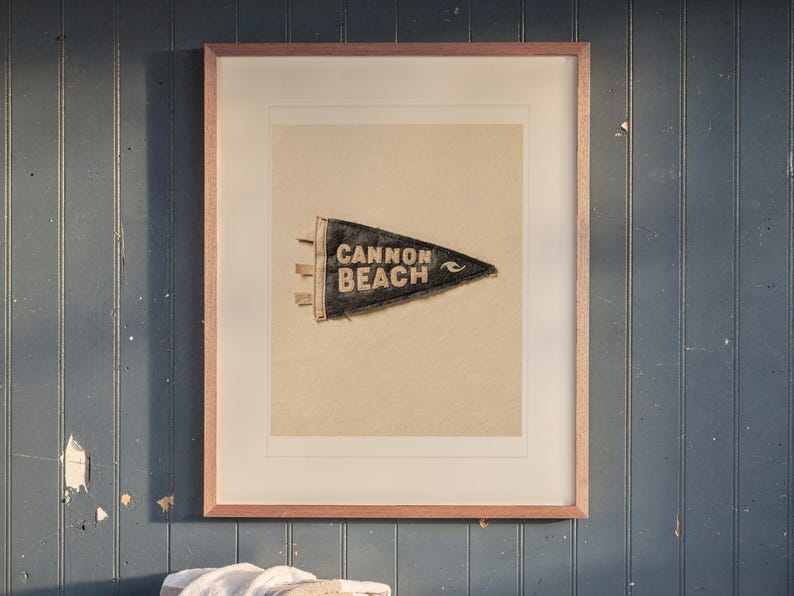 Cannon Beach print in a Red Oak frame with a white mat, hanging above the bench in a mudroom.