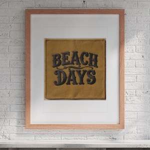 Beach Days Patch print in a Red Oak frame with a white mat, hanging above the cubbies in a mudroom.