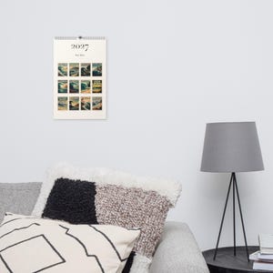 2027 Surf Spots wall calendar hanging in a calm living room.
