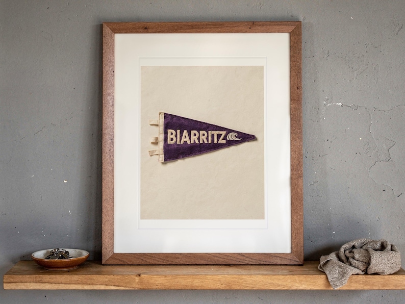 Biarritz print in a Red Oak frame with a white mat, leaning on the ledge against the wall in a hallway.