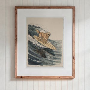 Golden Retriever Surfing print in a Red Oak frame with a white mat, hanging above the desk in a kids' room.