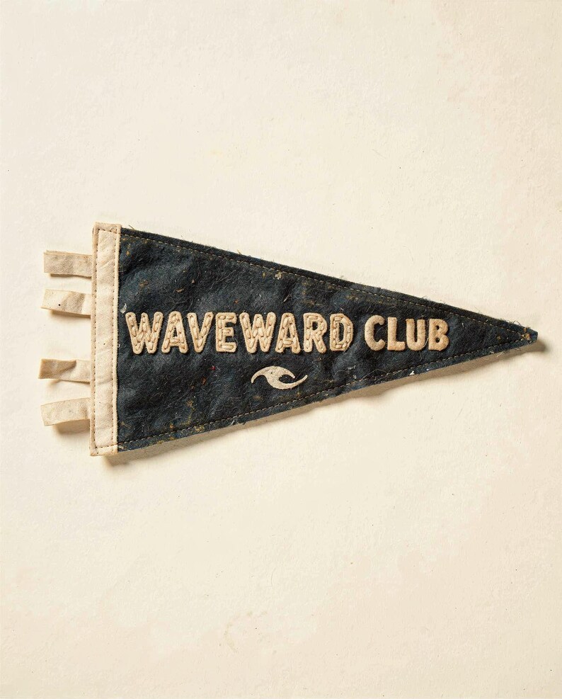 Full Waveward Club surf pennant artwork on a cream ground, showing the weathered felt texture and stitched lettering