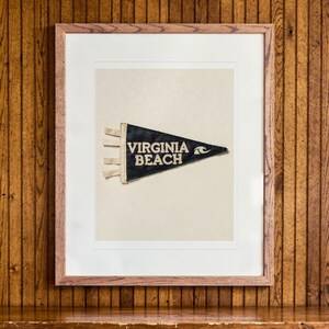 Virginia Beach Surf Pennant print in a Red Oak frame with a white mat, hanging above the credenza in a mid-century living room.