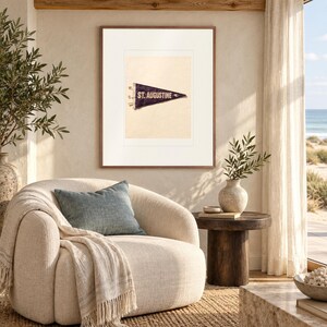 St. Augustine Surf Pennant print in a Red Oak frame with a white mat in a light-filled coastal sitting room.