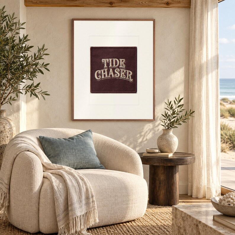 Tide Chaser Patch print in a Red Oak frame with a white mat in a light-filled coastal sitting room.