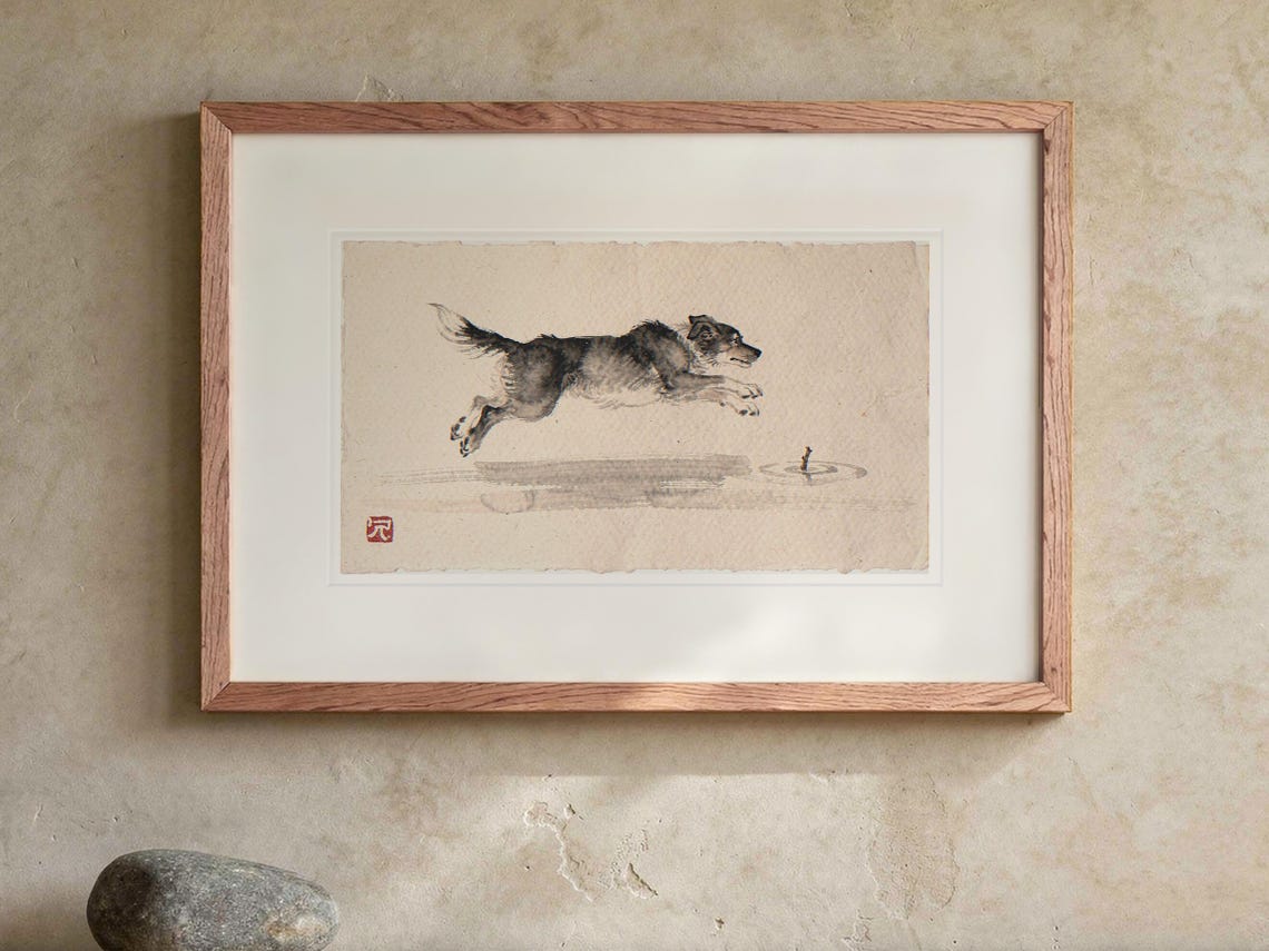 Dog Chasing a Stick Xieyi Ink print in a Red Oak frame with a white mat, hanging above the console in a japandi living room.