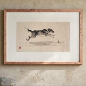 Dog Chasing a Stick Xieyi Ink print in a Red Oak frame with a white mat, hanging above the console in a japandi living room.