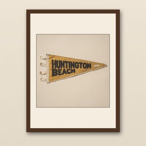 Huntington Beach Vintage Surf Pennant Print - walnut framed art print with cream mat on plaster wall