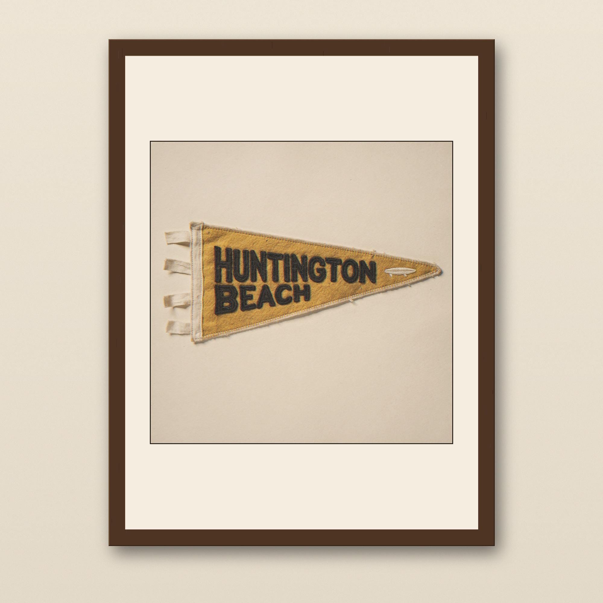 Huntington Beach Vintage Surf Pennant Print - walnut framed art print with cream mat on plaster wall