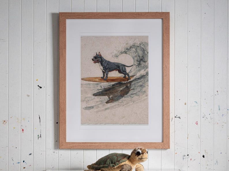 Pit Bull Surfing print in a Red Oak frame with a white mat, hanging above the bookshelf in a kids' room.