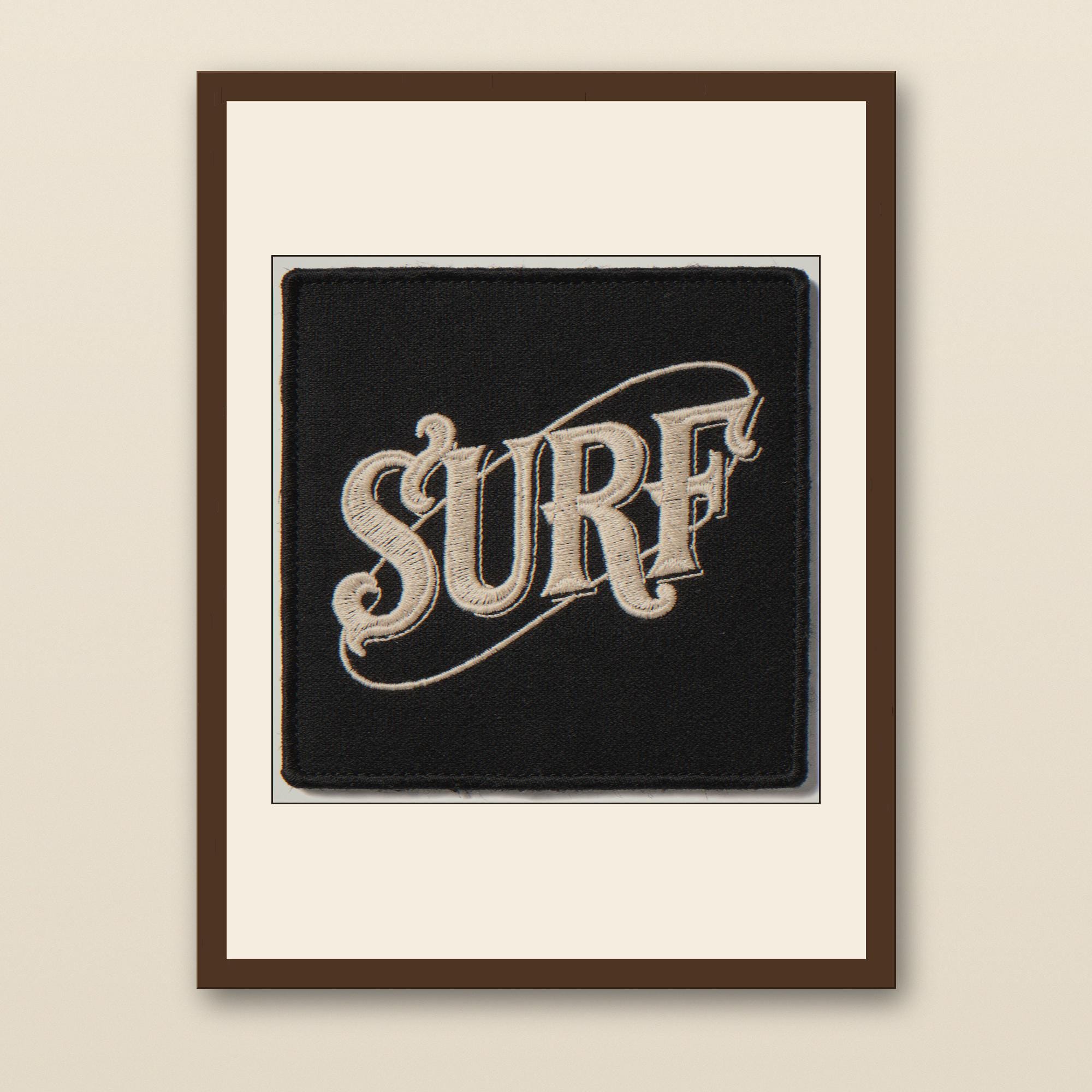 Surf Embroidered Patch Print - walnut framed art print with cream mat on plaster wall