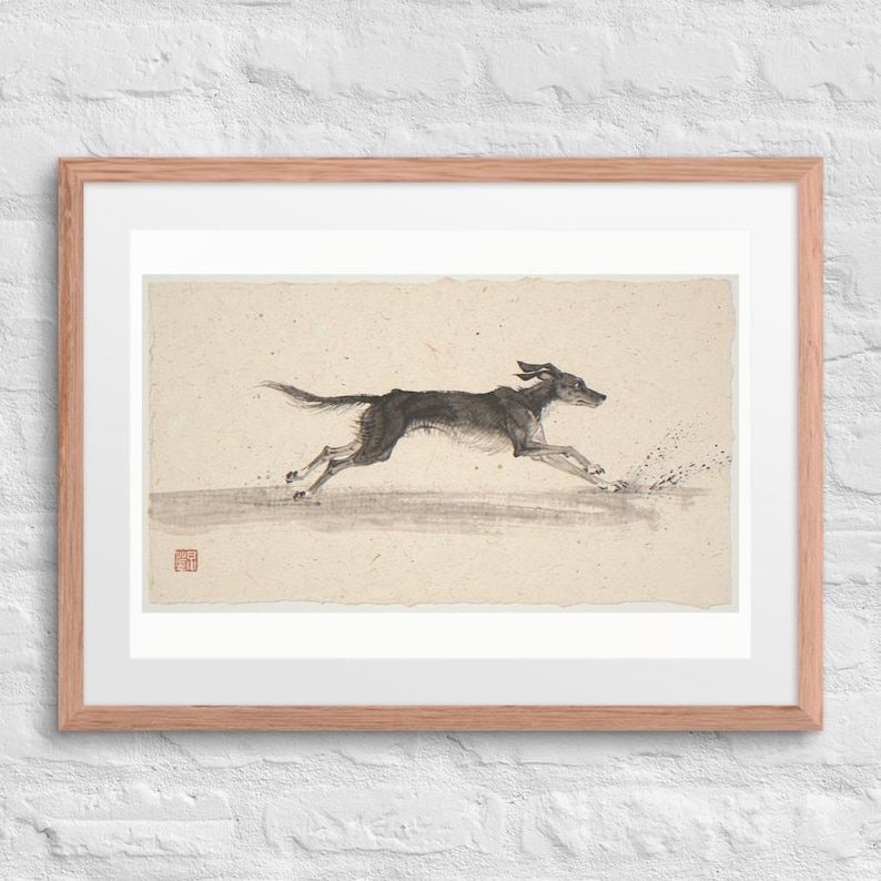 Dog Running on the Beach Xieyi Ink print in a Red Oak 24 by 18 inch frame with a white mat on a white brick wall.