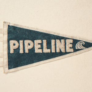 Pipeline Vintage Surf Pennant Print framed in a beach-style living room setting