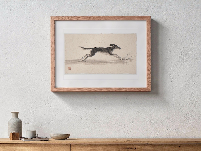 Dog Running on the Beach Xieyi Ink print in a Red Oak frame with a white mat, hanging above the console in a japandi living room.