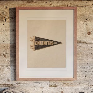 Encinitas print in a Red Oak frame with a white mat, hanging above the bench in a beach house loft.