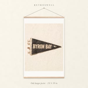 Byron Bay Surf Pennant oak hanger poster, 24 by 36 inches, with natural wood rails and a hanging cord.