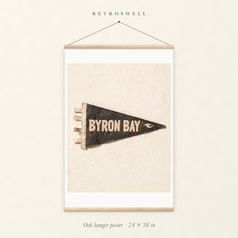 Byron Bay Surf Pennant oak hanger poster, 24 by 36 inches, with natural wood rails and a hanging cord.