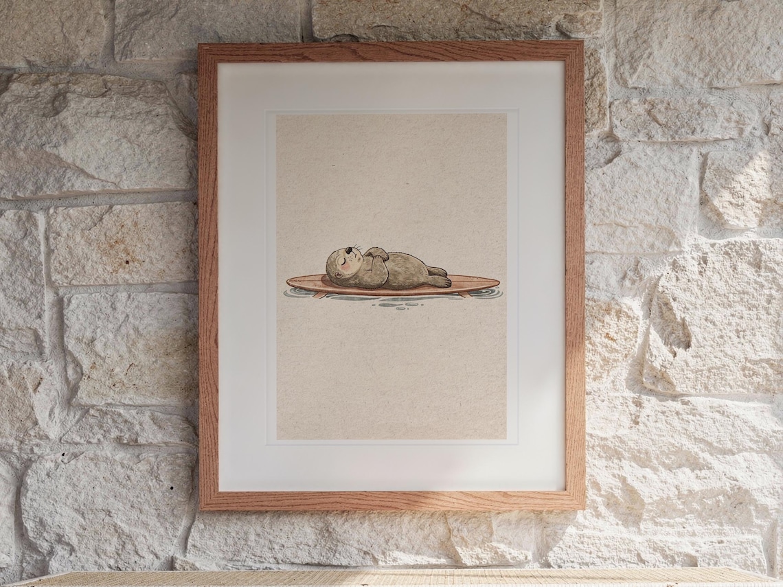 Sea Otter on Surfboard print in a Red Oak frame with a white mat, hanging above the console in a sunroom.