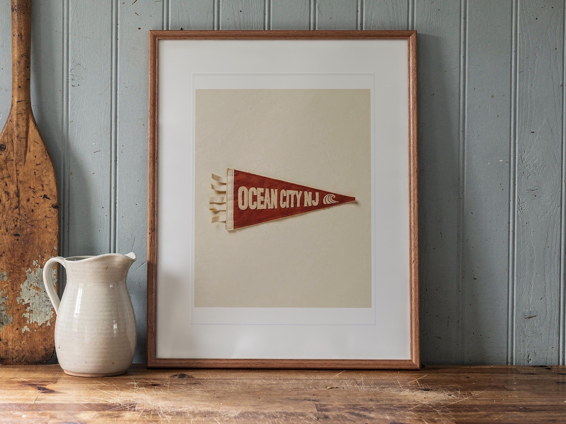 Ocean City print in a Red Oak frame with a white mat, leaning on the counter against the backsplash in a cottage kitchen.