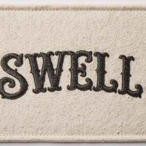 Swell Embroidered Patch Print framed in a beach-style living room setting