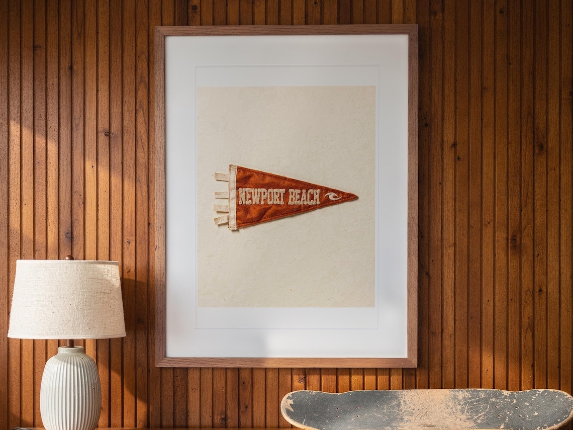 Newport Beach print in a Red Oak frame with a white mat, hanging above the credenza in a mid-century living room.