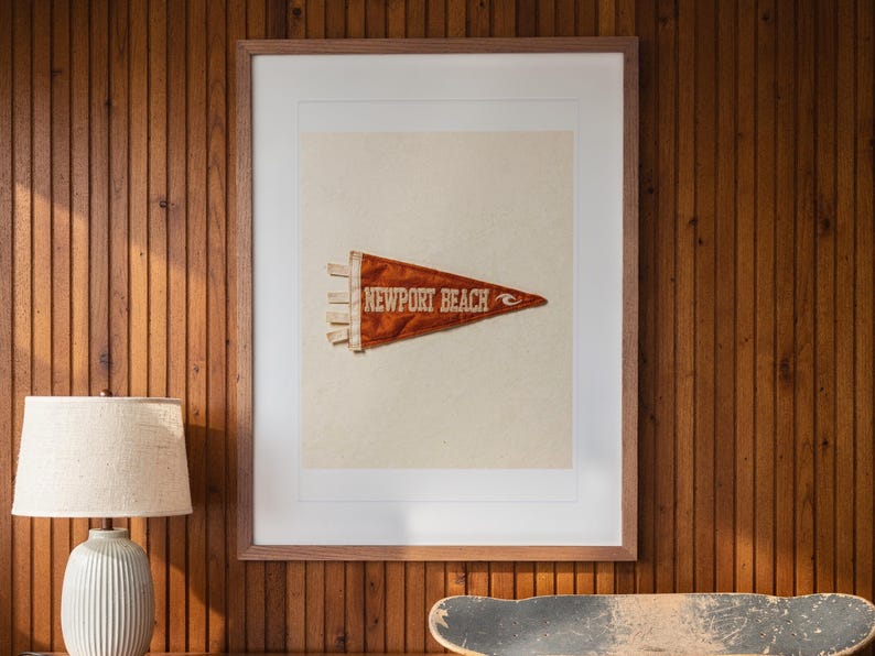 Newport Beach print in a Red Oak frame with a white mat, hanging above the credenza in a mid-century living room.