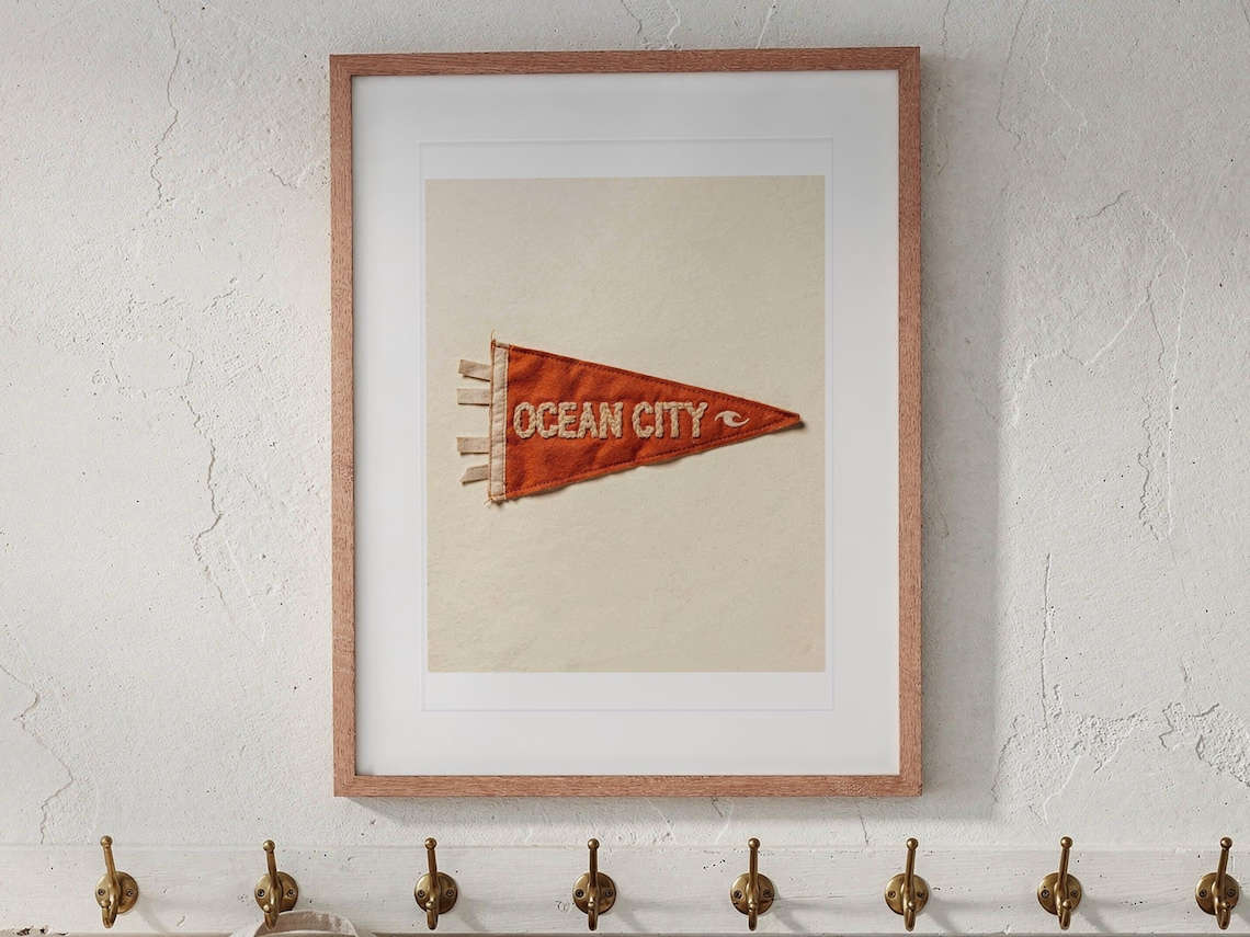 Ocean City print in a Red Oak frame with a white mat, hanging above the bench in a beach cottage entryway.