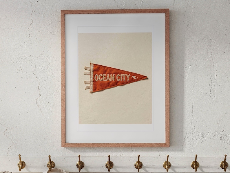 Ocean City print in a Red Oak frame with a white mat, hanging above the bench in a beach cottage entryway.